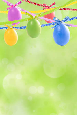 Holiday card with colorful easter eggs hang on ribbon and place for your textの写真素材