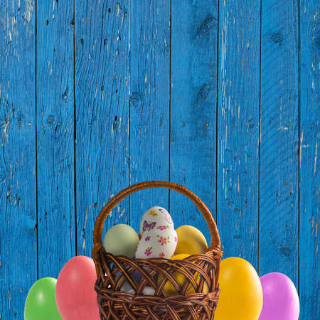 Holiday card with colorful Easter eggs in basket and place for your textの写真素材