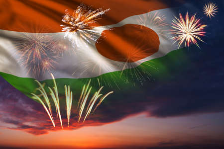 Holiday night sky with fireworks and flag of Niger for Independence dayの写真素材