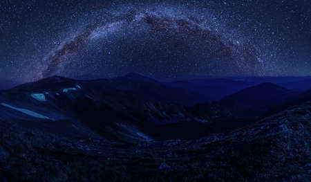 Beautiful night landscape with milky way over mountainsの写真素材