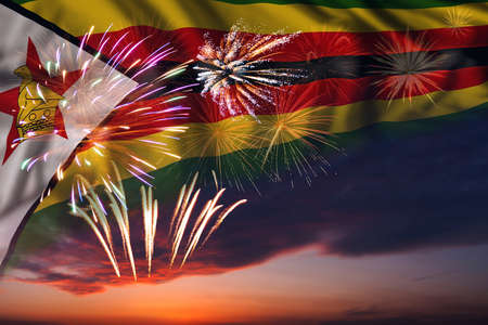Majestic fireworks in evening sky Holiday night sky with fireworks and flag of Zimbabwe for Independence dayの写真素材