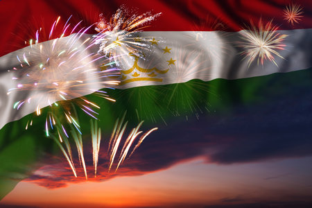 Majestic fireworks in evening sky and flag of Tajikistan for Independence day or National Holidayの写真素材