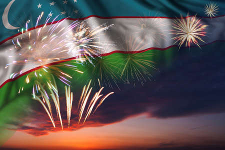Majestic fireworks in evening sky and flag of Uzbekistan for Independence day or National Holidayの写真素材