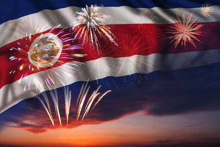 Majestic fireworks in evening sky and flag of Costa Rica for Independence day or National Holidayの写真素材
