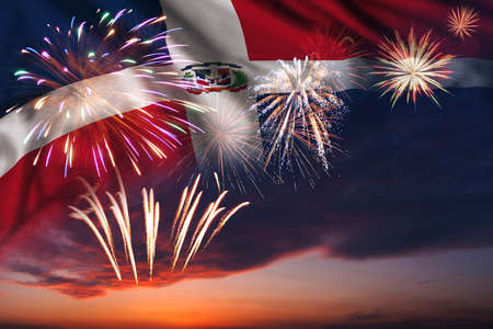 Majestic fireworks in evening sky and flag of Dominican Republic for Independence day or National Holidayの写真素材