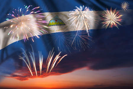 Majestic fireworks in evening sky and flag of Nicaragua for Independence day or National Holidayの写真素材