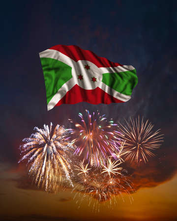 Holiday fireworks in evening sky and flag of Burundi for National Independence dayの写真素材