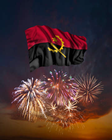 Holiday fireworks in evening sky and flag of Angola for National Independence dayの写真素材