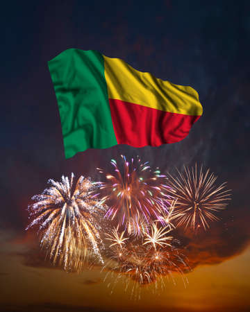 Holiday fireworks in evening sky and flag of Benin for National Independence dayの写真素材