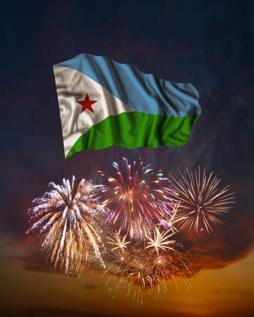 Holiday fireworks in evening sky and flag of Djibouti for National Independence dayの写真素材