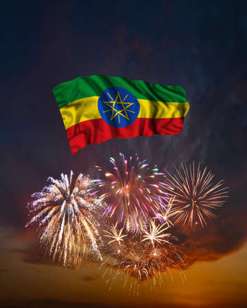 Holiday fireworks in evening sky and flag of Ethiopia for National Independence dayの写真素材