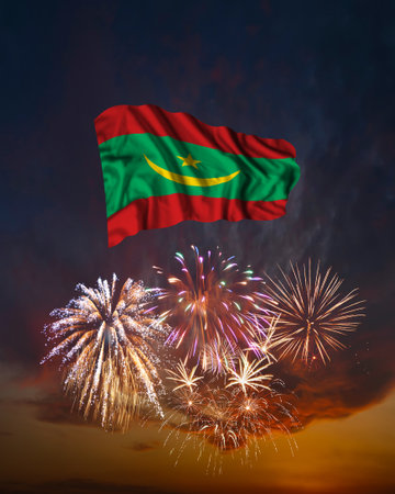 Holiday fireworks in evening sky and flag of Mauritania for National Independence dayの写真素材