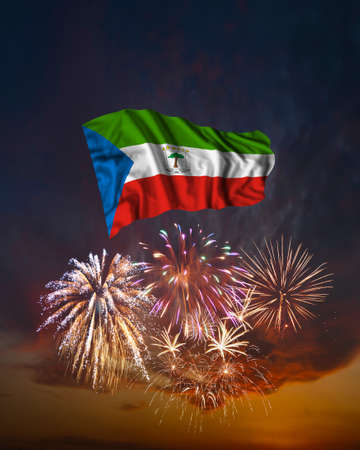 Holiday fireworks in evening sky and flag of Equatorial Guinea for National Independence dayの写真素材