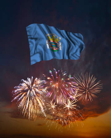 Holiday fireworks in evening sky and flag of Melilla for National Independence dayの写真素材