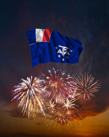 Holiday fireworks in evening sky and flag of French Southern and Antarctic Lands for National Independence dayの写真素材