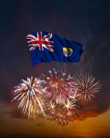 Holiday fireworks in evening sky and flag of Saint Helena for National Independence dayの写真素材