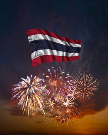 Holiday fireworks in evening sky and flag of Thailand for National Independence dayの写真素材