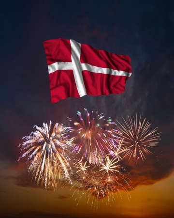 Holiday fireworks in evening sky and flag of Denmark for National Independence dayの写真素材