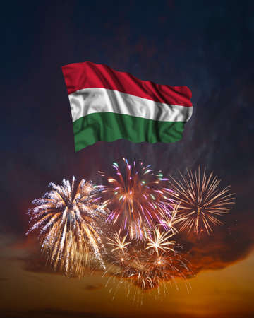 Holiday fireworks in evening sky and flag of Hungary for National Independence dayの写真素材