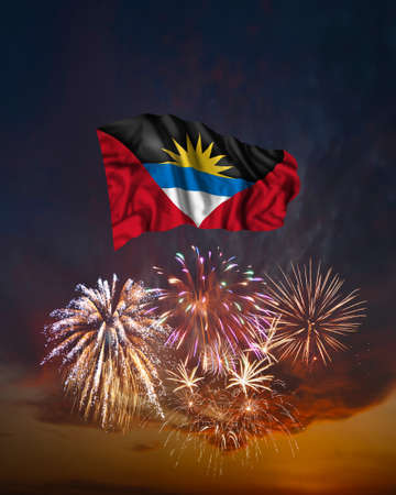 Holiday fireworks in evening sky and flag of Antigua and Barbuda for National Independence dayの写真素材