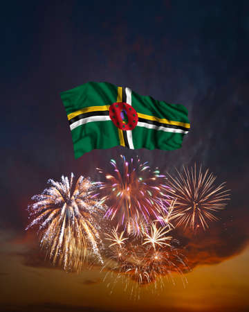 Holiday fireworks in evening sky and flag of Dominica for National Independence dayの写真素材