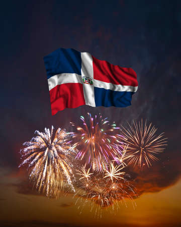 Holiday fireworks in evening sky and flag of Dominican Republic for National Independence dayの写真素材