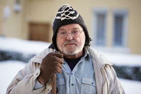 Senior man in Warm Clothing holding Snow Shovel