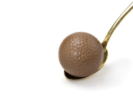 Chocolate golf ball on a gold spoonの写真素材