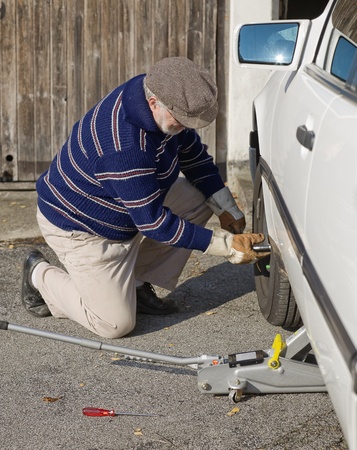 Senior man changing a tireの写真素材