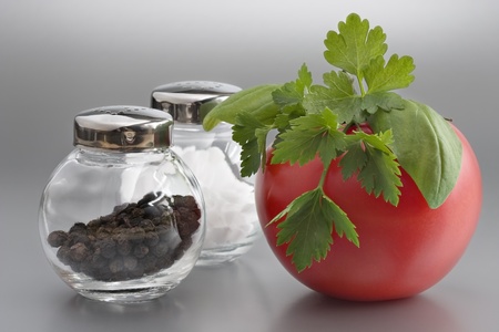 Salt, pepper and red tomato on greyの写真素材