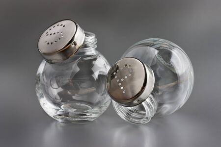 Empty salt and pepper shakers on greyの写真素材