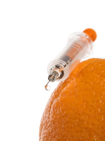 Syringe with drop on orange fruit, close-upの写真素材