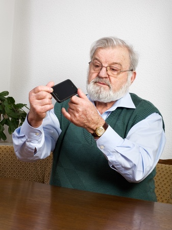 Senior man checking his new smart phoneの写真素材