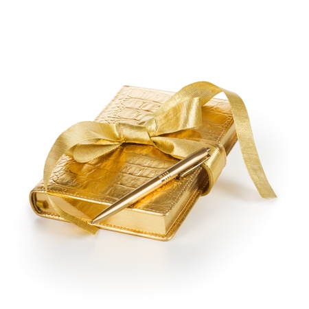 Luxury gift diary with gold ribbon and pen on white backgroundの写真素材