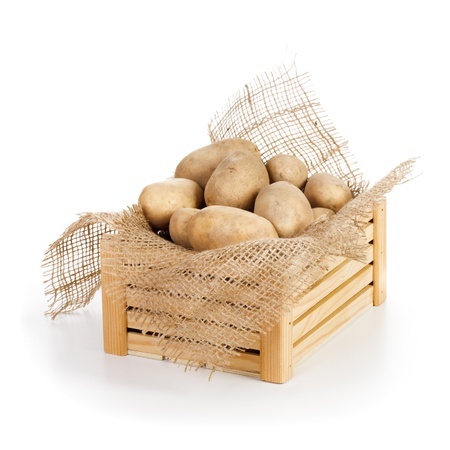 Wooden box of raw potatoes on white backgroundの写真素材