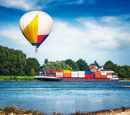Container ship on the river. Air hot balloon floating over summer landscapeの写真素材
