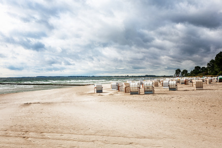 Sandy beach with beach chairs. Late summer landscape with cloudy sky. Vacation background. Baltic sea coast, travel destinationの写真素材