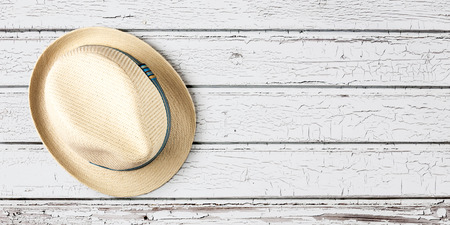 Straw hat with blue ribbon isolated on wooden plank background, single object with clipping path....