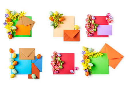 Easter greeting card with flowers, eggs, note paper and envelopes collection. Holiday composition isolated on white background. Spring arrangement and design element, top view, flat layの写真素材
