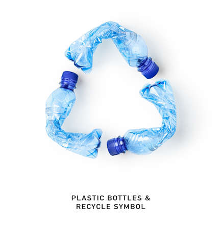 Recycle symbol made of used plastic bottles isolated on white background. Environmental recycling concept. Creative composition and design element. Top view, flat layの写真素材