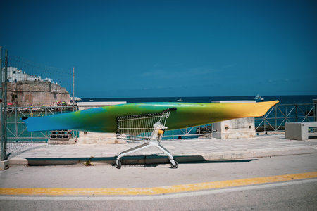 Surfboard left in a caddy on a road by the sea.