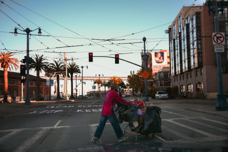 A homeless man crosses a street in San Francisco.のeditorial素材