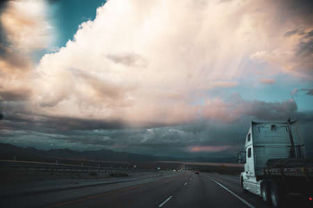 A truck on a long straight road in Nevadaの写真素材