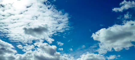 Deep blue sky background with beautiful white cloudsの写真素材