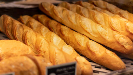 Freshly baked french bread baguettes on a bakery, ready to sell - selective focus