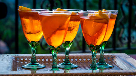 glasses of  cocktail with ice cubes and orange slices - summer refreshing drink conceptの写真素材