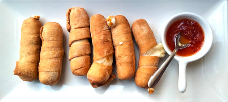 Cheese sticks with pepper sauce - TequeÃ±os authentic original Venezuelan appetizer made of fried corn filled with cheese - top viewの写真素材