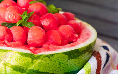 sweet and juicy watermelon small balls and mint salad, served using the skin as a bowl. Summer food concept. Selective focus. Close upの写真素材