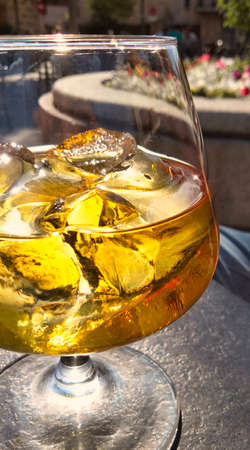 close-up of one glass of whiskey on the rocks in a table of a terrace bar on a sunny day. Break time conceptの写真素材