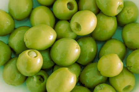 Pile of green pitted olives as an appetizer, as an ingredient or for cocktails - close upの写真素材